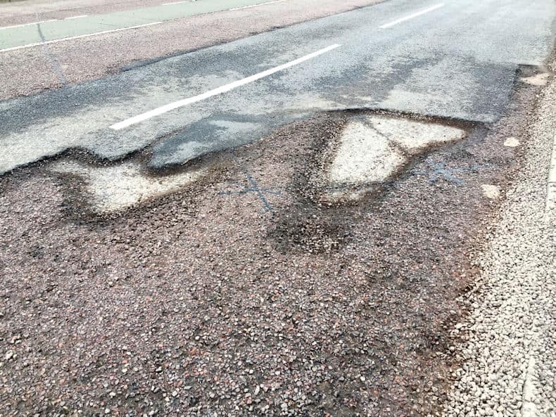 Pothole in the road looking like an island